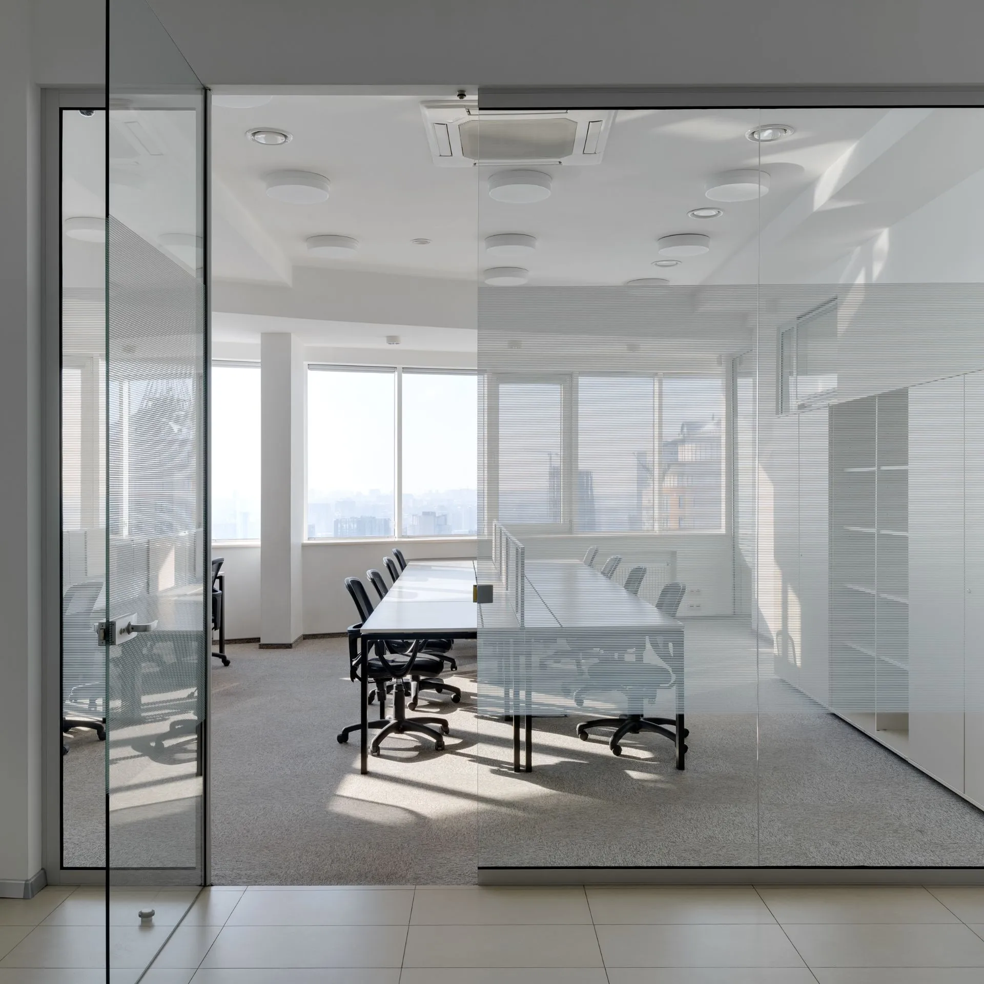 A professional glazier preparing a high-quality glass pane for a modern office partition installation in Dallas.